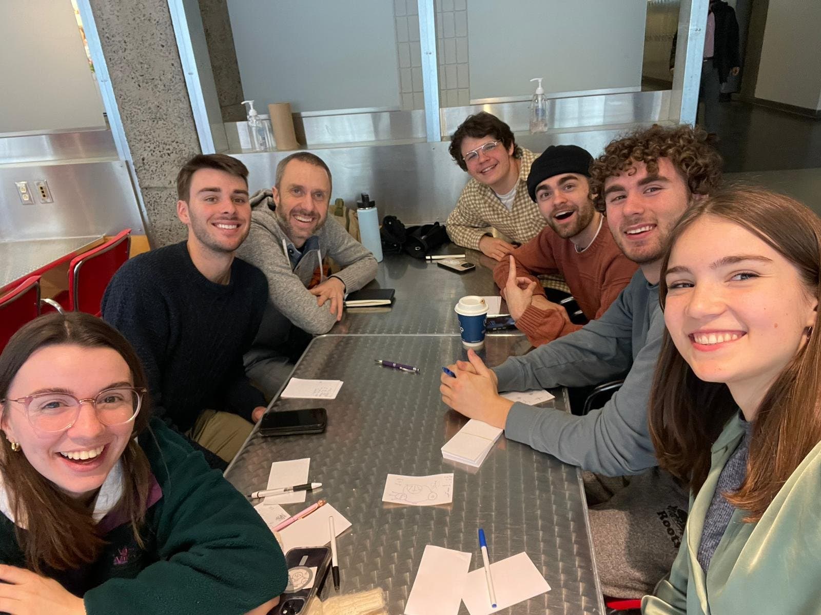 Un grupo pequeño trabajando juntos con las herramientas alrededor de una mesa
